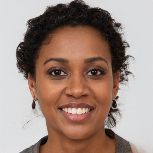Joyful black young-adult female with short  brown hair and brown eyes
