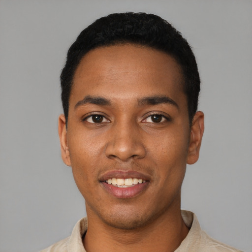 Joyful black young-adult male with short  black hair and brown eyes