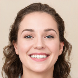 Joyful white young-adult female with long  brown hair and green eyes