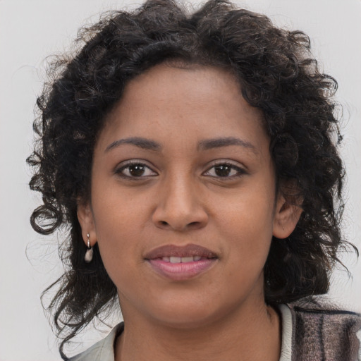 Joyful black young-adult female with long  brown hair and brown eyes