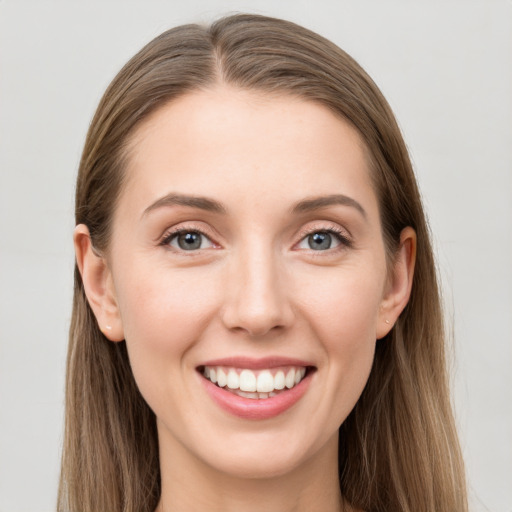 Joyful white young-adult female with long  brown hair and blue eyes