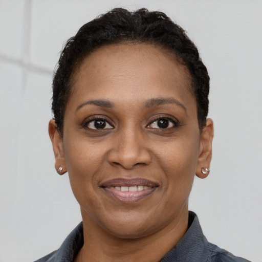 Joyful black young-adult female with short  brown hair and brown eyes