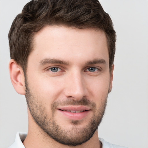 Joyful white young-adult male with short  brown hair and grey eyes