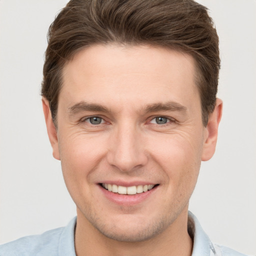 Joyful white young-adult male with short  brown hair and grey eyes