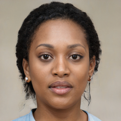 Joyful black young-adult female with long  black hair and brown eyes