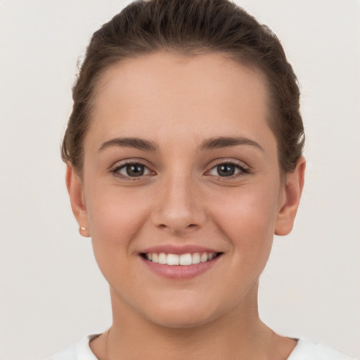 Joyful white young-adult female with short  brown hair and brown eyes