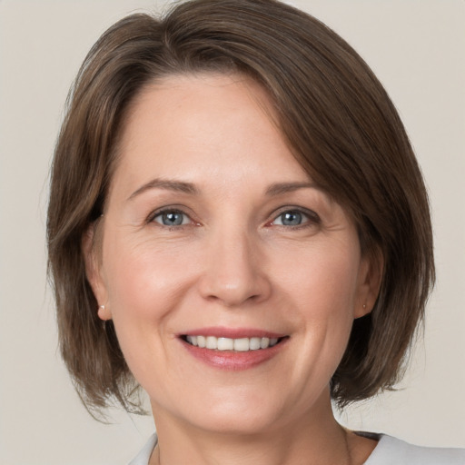 Joyful white adult female with medium  brown hair and brown eyes