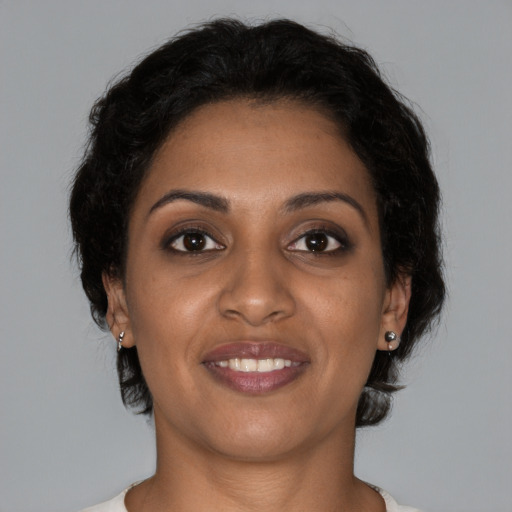 Joyful black young-adult female with short  brown hair and brown eyes