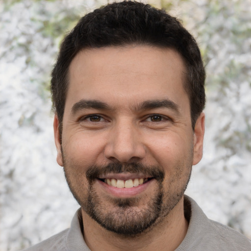 Joyful white young-adult male with short  black hair and brown eyes