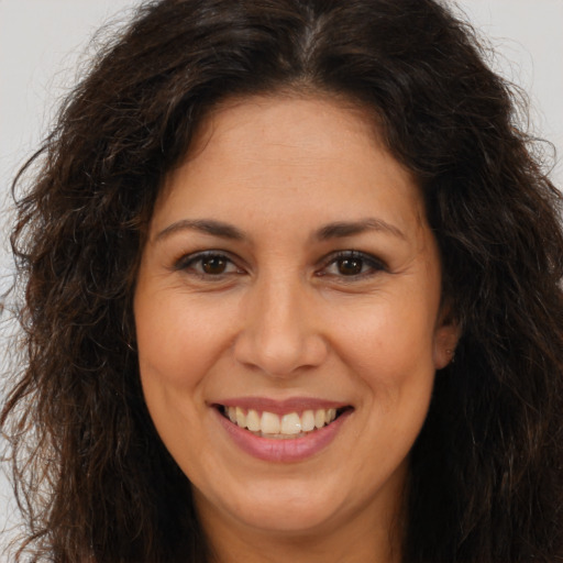 Joyful white adult female with long  brown hair and brown eyes