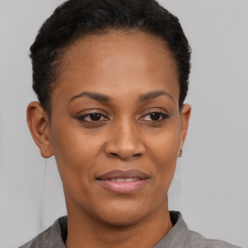 Joyful black young-adult female with short  brown hair and brown eyes