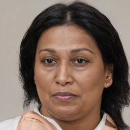 Joyful latino adult female with medium  brown hair and brown eyes