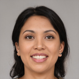 Joyful latino young-adult female with medium  brown hair and brown eyes