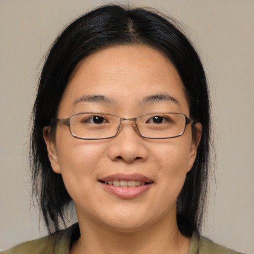 Joyful asian adult female with medium  brown hair and brown eyes