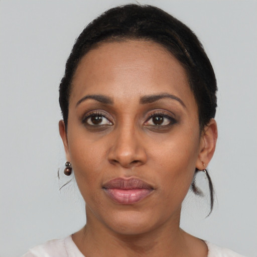 Joyful black young-adult female with short  black hair and brown eyes