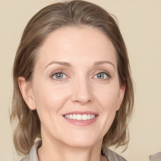 Joyful white young-adult female with medium  brown hair and grey eyes