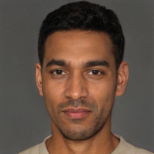 Joyful black young-adult male with short  black hair and brown eyes