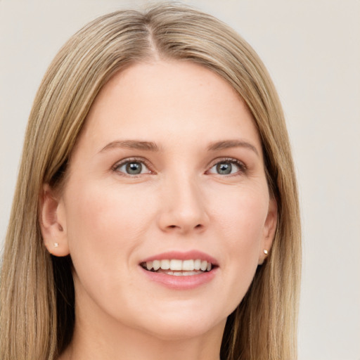 Joyful white young-adult female with long  brown hair and blue eyes