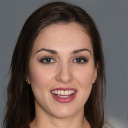 Joyful white young-adult female with long  brown hair and brown eyes