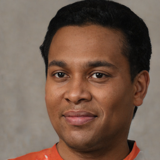 Joyful black young-adult male with short  black hair and brown eyes