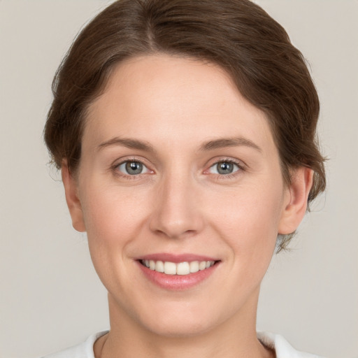 Joyful white young-adult female with medium  brown hair and green eyes