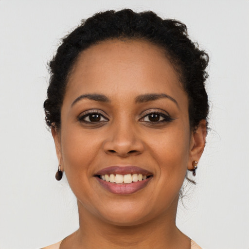 Joyful black young-adult female with long  brown hair and brown eyes