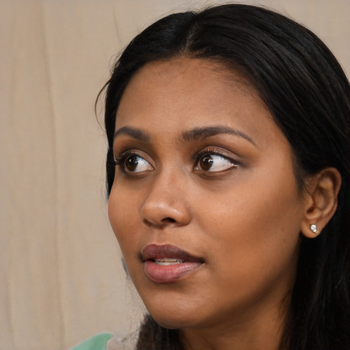 Joyful black young-adult female with long  black hair and brown eyes