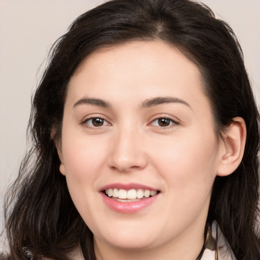 Joyful white young-adult female with long  brown hair and brown eyes