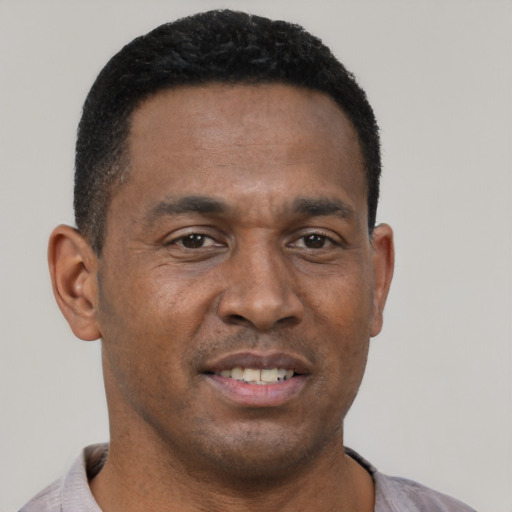 Joyful black young-adult male with short  brown hair and brown eyes