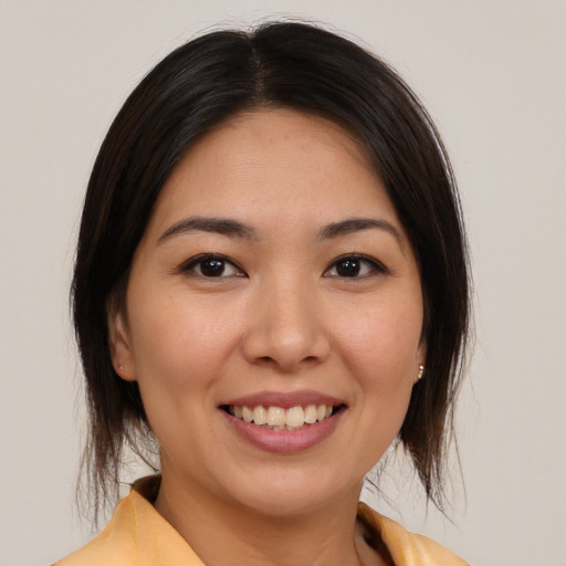 Joyful asian young-adult female with medium  brown hair and brown eyes