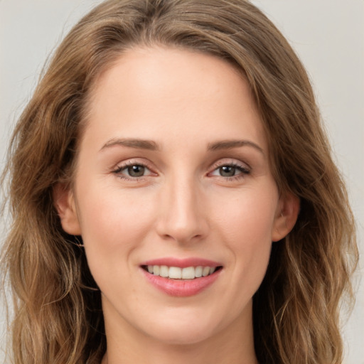 Joyful white young-adult female with long  brown hair and green eyes