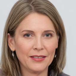 Joyful white adult female with medium  brown hair and grey eyes