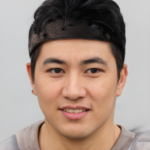 Joyful asian young-adult male with short  black hair and brown eyes