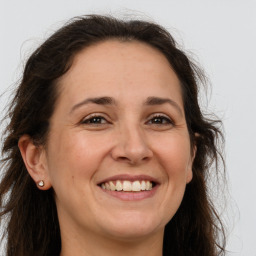 Joyful white adult female with long  brown hair and brown eyes