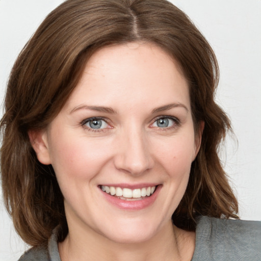 Joyful white young-adult female with medium  brown hair and green eyes