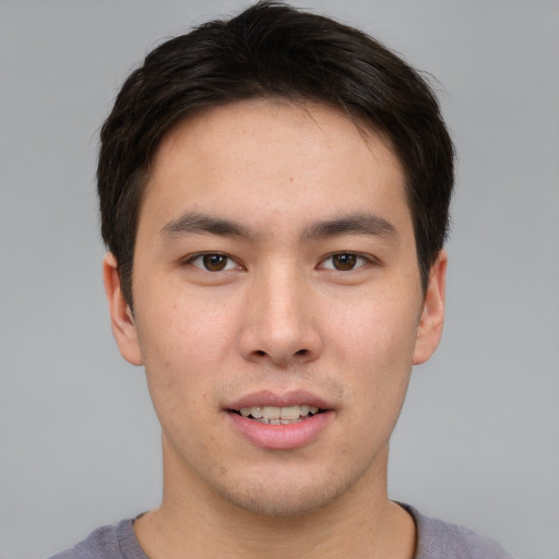 Joyful asian young-adult male with short  brown hair and brown eyes