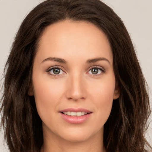 Joyful white young-adult female with long  brown hair and brown eyes