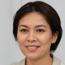 Joyful asian young-adult female with medium  brown hair and brown eyes