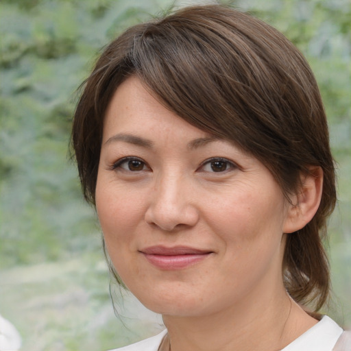 Joyful white adult female with medium  brown hair and brown eyes