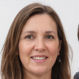 Joyful white adult female with long  brown hair and grey eyes