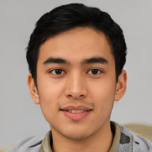 Joyful latino young-adult male with short  brown hair and brown eyes