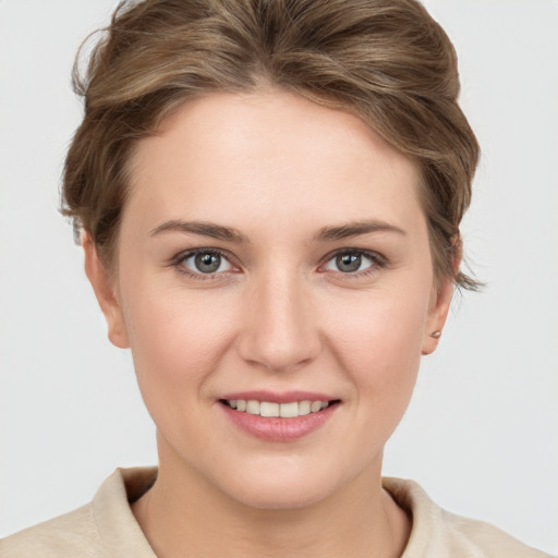 Joyful white young-adult female with short  brown hair and grey eyes