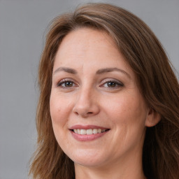 Joyful white adult female with long  brown hair and brown eyes