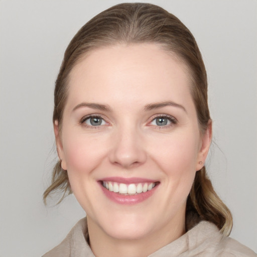 Joyful white young-adult female with medium  brown hair and grey eyes