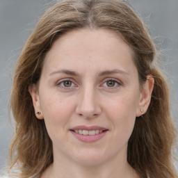 Joyful white adult female with long  brown hair and grey eyes