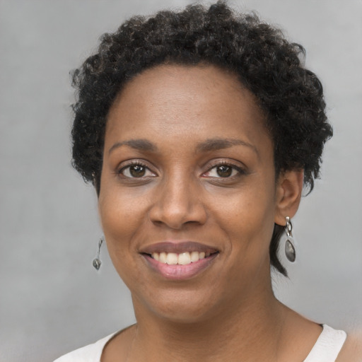 Joyful black young-adult female with short  brown hair and brown eyes