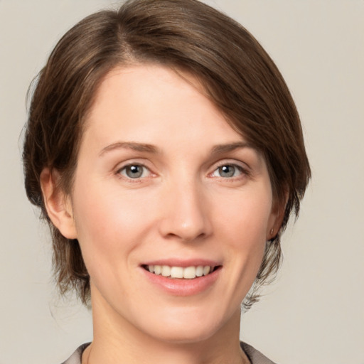 Joyful white young-adult female with medium  brown hair and grey eyes