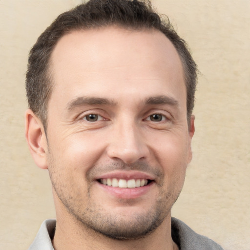 Joyful white young-adult male with short  brown hair and brown eyes