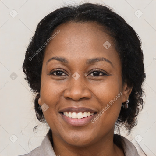 Joyful black adult female with medium  brown hair and brown eyes