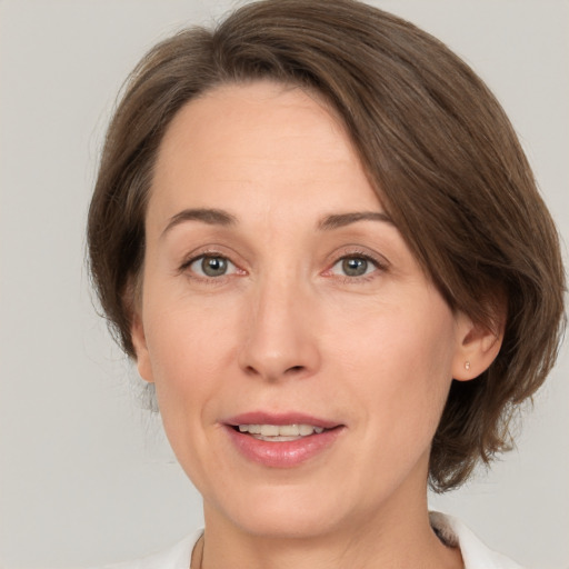 Joyful white adult female with medium  brown hair and green eyes